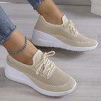 Baskets beiges en maille respirante pour femme, semelle épaisse blanche, style décontracté, mode, confort, portées avec un jean et bracelet chaîne.