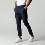 Pantalon chino bleu marine pour homme, coupe ajustée, porté avec un t-shirt blanc et des baskets blanches. Mode masculine élégante et décontractée.