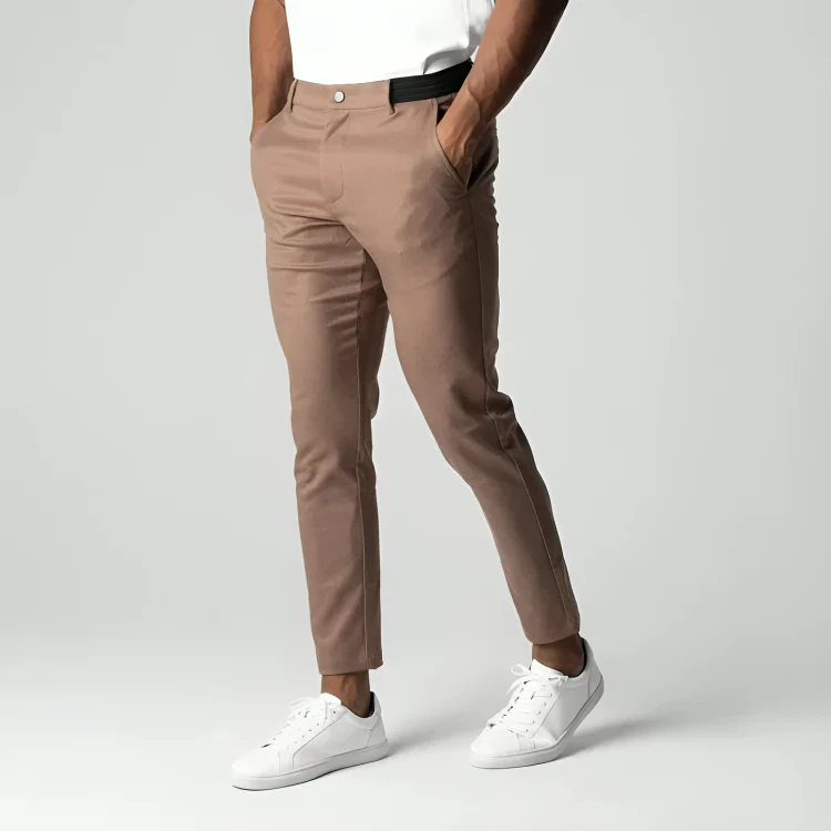 Pantalon chino beige pour homme, coupe ajustée, avec poches, porté avec des baskets blanches et un t-shirt blanc. Mode masculine élégante.