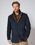 Homme portant une veste en velours bleu marine avec col marron, chemise kaki et pantalon beige. Mode masculine élégante, style automne-hiver.