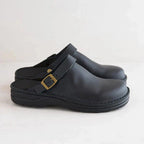 Sabots en cuir noir avec bride réglable et boucle dorée, design moderne et confortable, parfaits pour un style décontracté et élégant.