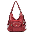 Sac à main rouge en cuir synthétique avec bandoulière réglable, poches zippées et détails métalliques. Accessoire mode femme élégant et pratique.