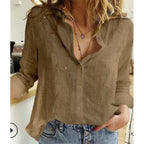 Femme portant une chemise en lin marron, manches retroussées, avec un collier pendentif, associée à un jean bleu. Mode décontractée chic.