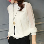 Blouse blanche élégante avec manches transparentes, col montant et pendentif long. Mode féminine chic, tenue décontractée, style moderne.