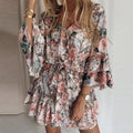 Robe à fleurs roses et bleues avec manches évasées, portée par une femme blonde. Style bohème chic, tendance mode féminine printemps-été.