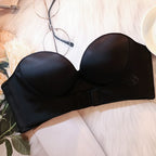 Soutien-gorge noir sans bretelles sur fond blanc, à côté de lunettes et fleurs. Lingerie féminine élégante, accessoire mode essentiel.
