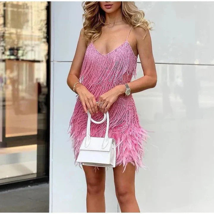 Robe rose à franges portée par une femme, accessoirisée d'un sac à main blanc. Mode féminine élégante, tenue de soirée tendance.