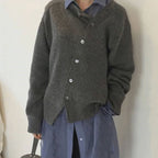 Femme portant un cardigan gris en laine sur une chemise bleue, style décontracté et élégant, mode automne-hiver, vêtements confortables et tendance.