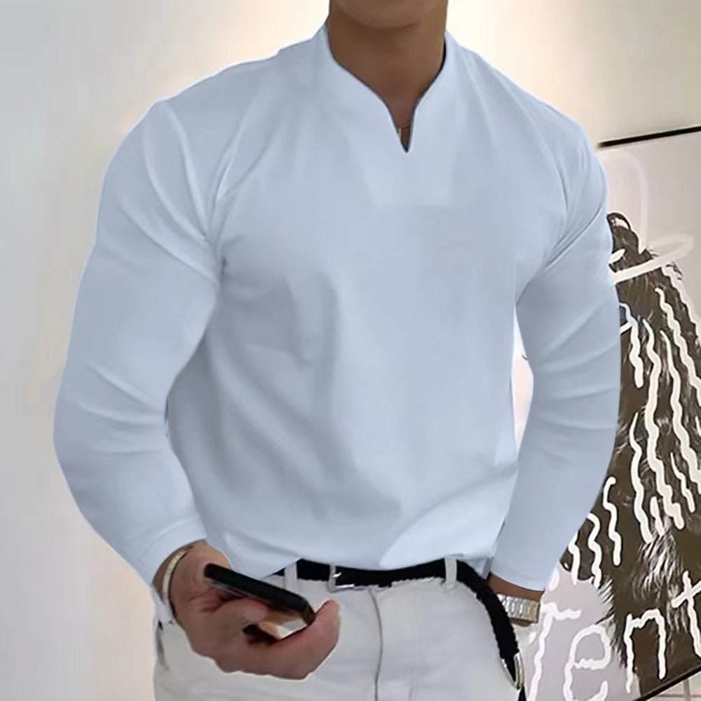 Homme en chemise blanche élégante, manches longues, tenant un smartphone. Mode masculine moderne, style décontracté chic.