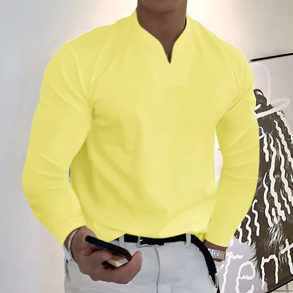 Homme en chemise jaune vif, manches longues, tenant un smartphone. Style moderne et décontracté, idéal pour mode masculine tendance.