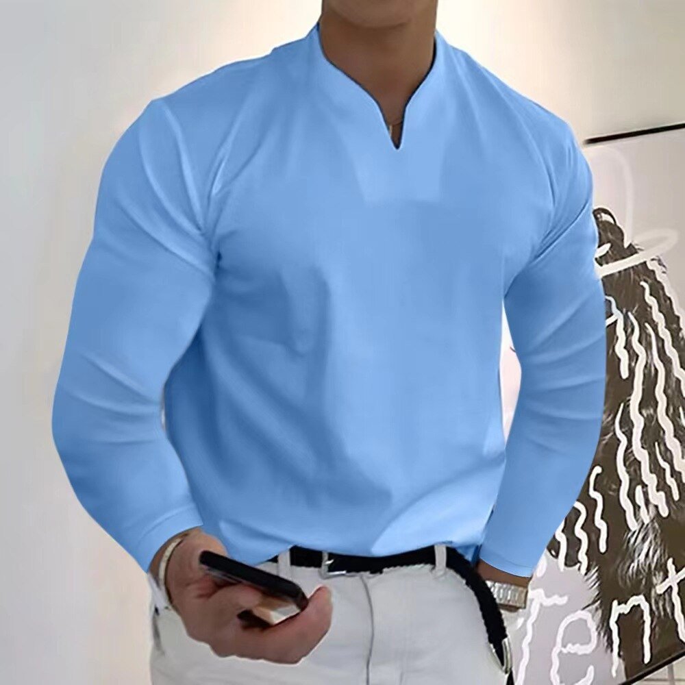 Homme en chemise bleue à manches longues, tenant un smartphone. Mode masculine élégante, tenue décontractée, style moderne.