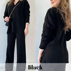 Femme portant un ensemble noir élégant, composé d'un pull ample et d'un pantalon large. Mode automne-hiver, tenue chic et confortable.