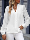 Femme portant une chemise blanche élégante avec manches longues texturées, posant en extérieur urbain. Mode féminine chic, tenue décontractée.