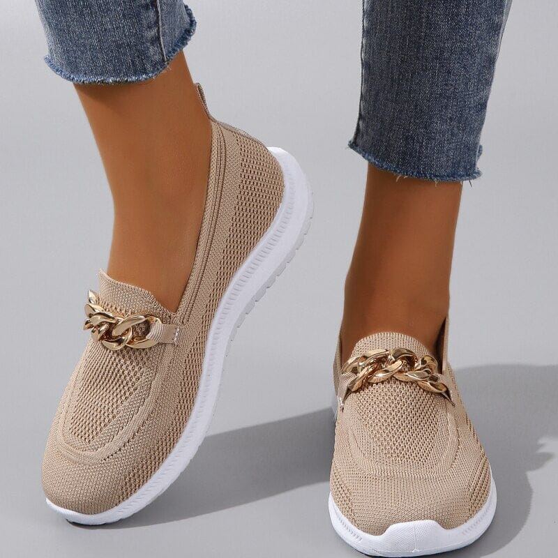 Chaussures en maille beige avec chaîne dorée, semelle blanche, portées avec un jean. Style décontracté, tendance, confort, mode féminine.