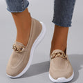 Chaussures en maille beige avec chaîne dorée, semelle blanche, portées avec un jean. Style décontracté, tendance, confort, mode féminine.