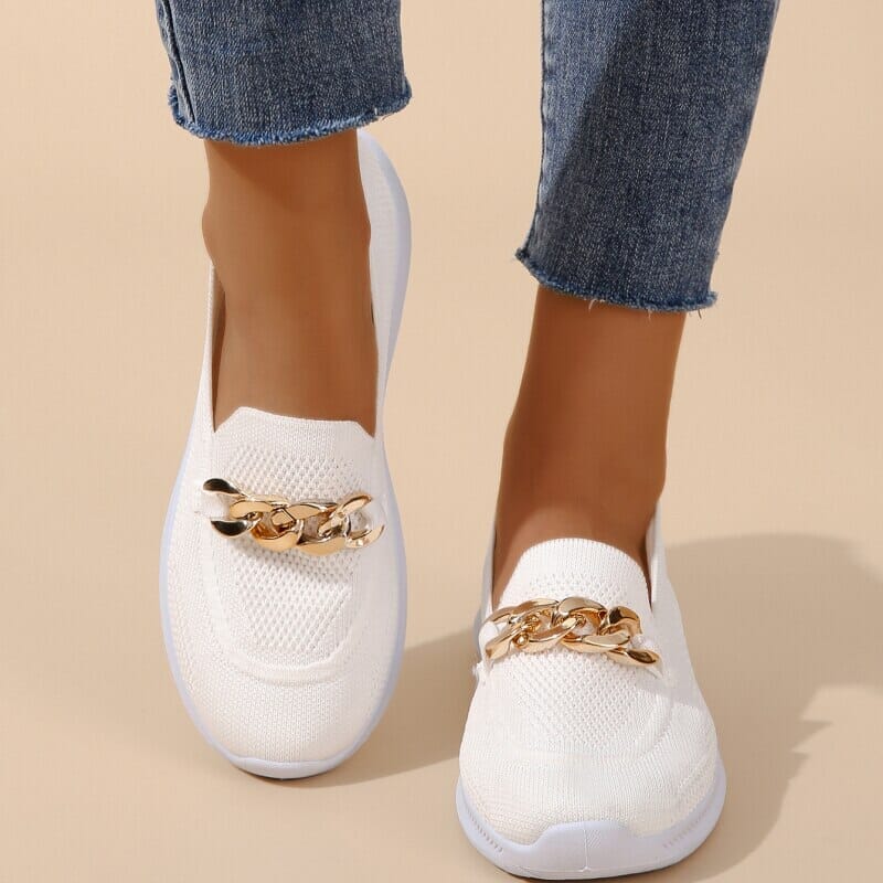 Chaussures blanches en maille avec chaîne dorée, portées avec un jean. Style décontracté, tendance et élégant pour femme. Mode printemps-été.