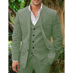 Homme en costume vert olive trois pièces, chemise blanche, posant en extérieur. Mode masculine élégante, tenue formelle, style moderne.