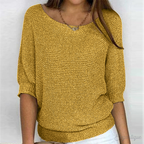 Femme portant un pull jaune en tricot, manches trois-quarts, col bateau, avec un collier. Mode automne, style décontracté, tendance féminine.