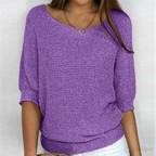 Femme portant un pull violet en tricot, manches trois-quarts, col bateau, avec un collier doré. Mode féminine, tendance automne-hiver.