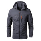Veste imperméable homme gris foncé avec capuche, fermeture éclair, poche poitrine zippée, idéale pour randonnée et activités extérieures.