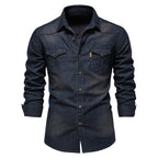 Chemise en jean bleu foncé pour homme avec manches longues, poches à rabat et boutons marron, style décontracté et moderne.