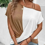 Femme portant un t-shirt bicolore marron et blanc, épaules dénudées, avec colliers dorés et bracelets, mode décontractée tendance.
