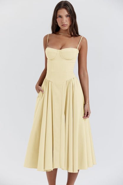Robe jaune élégante à bretelles fines, coupe évasée, portée par une femme. Mode féminine, tenue estivale chic, style décontracté.