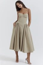 Robe beige élégante avec corsage ajusté et jupe évasée, portée par une femme. Mode féminine, tenue chic, style soirée, tendance 2023.