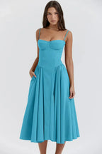 Robe bleue élégante à bretelles fines, coupe évasée, portée par une femme. Mode féminine, style chic, tenue estivale tendance.