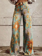Pantalon évasé à motifs floraux colorés, fond bleu, grandes fleurs orange et blanches, style vintage, mode rétro, mur en arrière-plan.