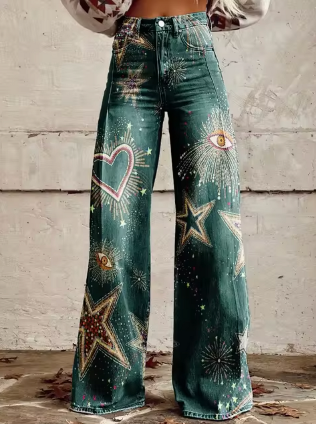 Jean évasé vert avec motifs étoiles, cœurs et yeux, style bohème chic. Pantalon tendance pour femme, mode décontractée et originale.