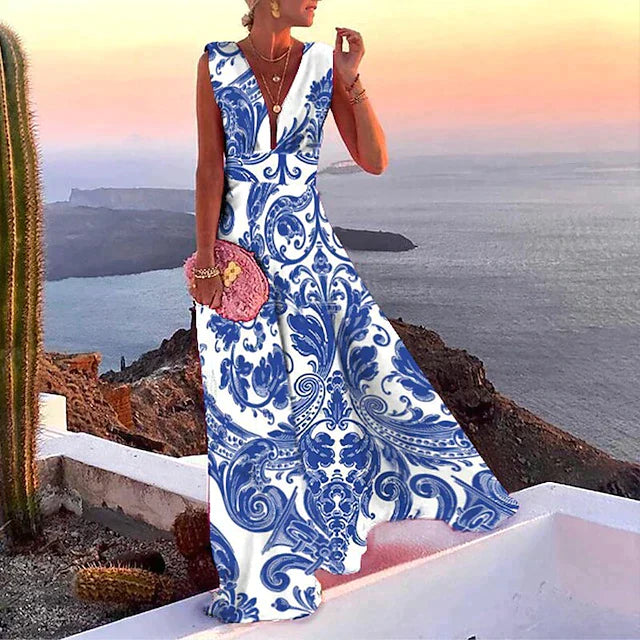 Robe longue d'été bleue et blanche à motifs floraux, femme élégante en bord de mer au coucher du soleil, style bohème chic, vacances île.