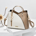 Sac à main en cuir bicolore beige et blanc avec poignée dorée, bandoulière amovible, et porte-clés cœur. Accessoire mode élégant pour femme.