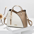 Sac à main en cuir bicolore beige et blanc avec poignée dorée, bandoulière amovible, et porte-clés cœur. Accessoire mode élégant pour femme.
